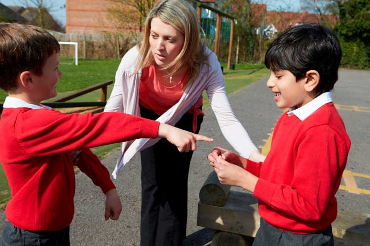 A teacher consuling two students who are having a disagreement