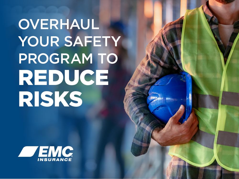 Warehouse worker wearing safety gear and holding hard hat