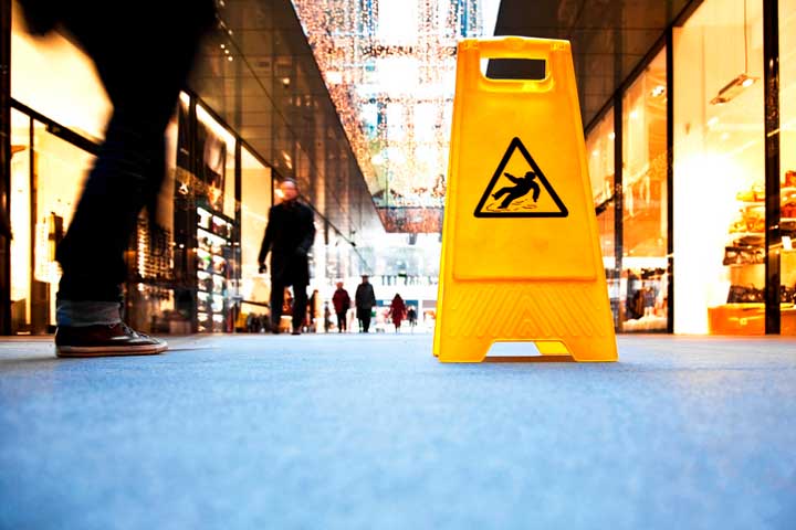 Shopping mall with a yellow sign over a wet spot on the floor