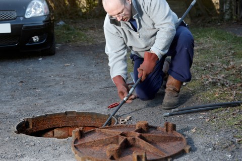 Plumber using a tool to clean a sewer line