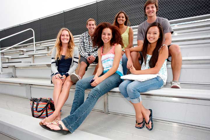 Six students sitting on bleachers