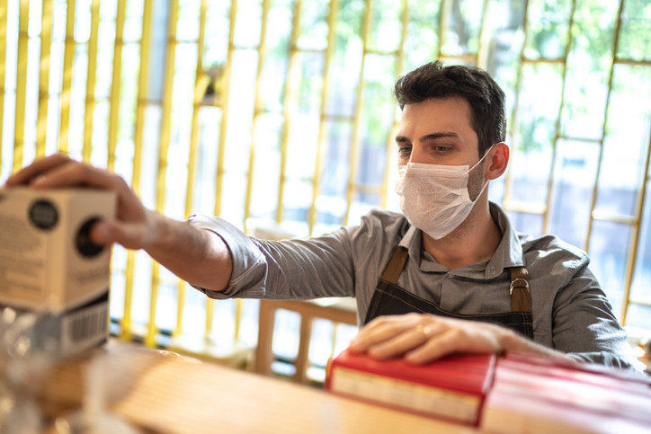 Man working in store with mask on.