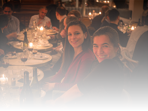 Two young women smiling at a dinner party, Paris.