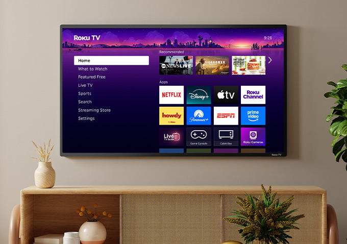 Roku TV mounted on a wall with a Roku Streambar SE underneath