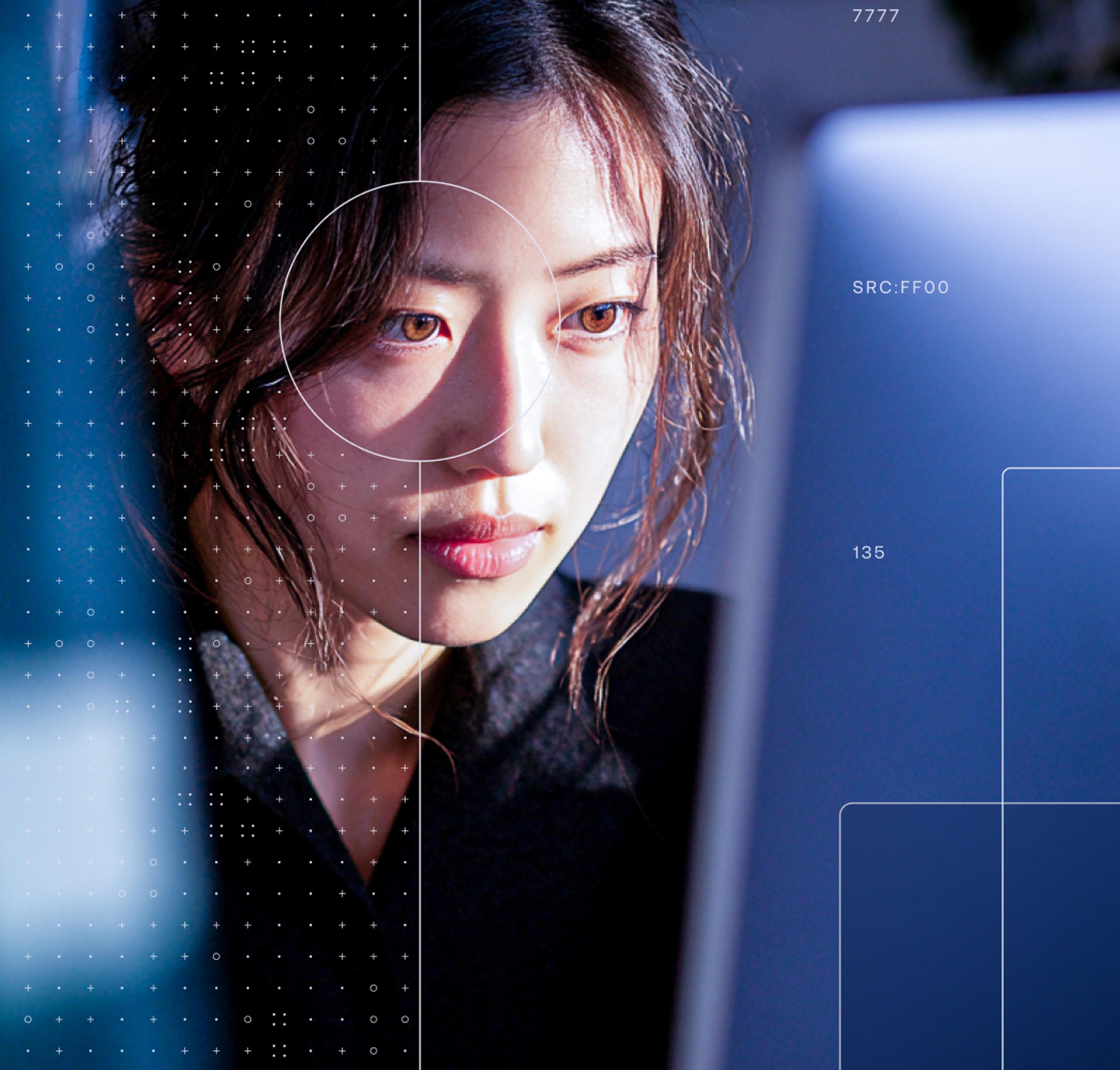 Close-up of a young woman looking at a laptop; warm front-left light, dark background, HUD overlay with dots and numbers 09 15 16