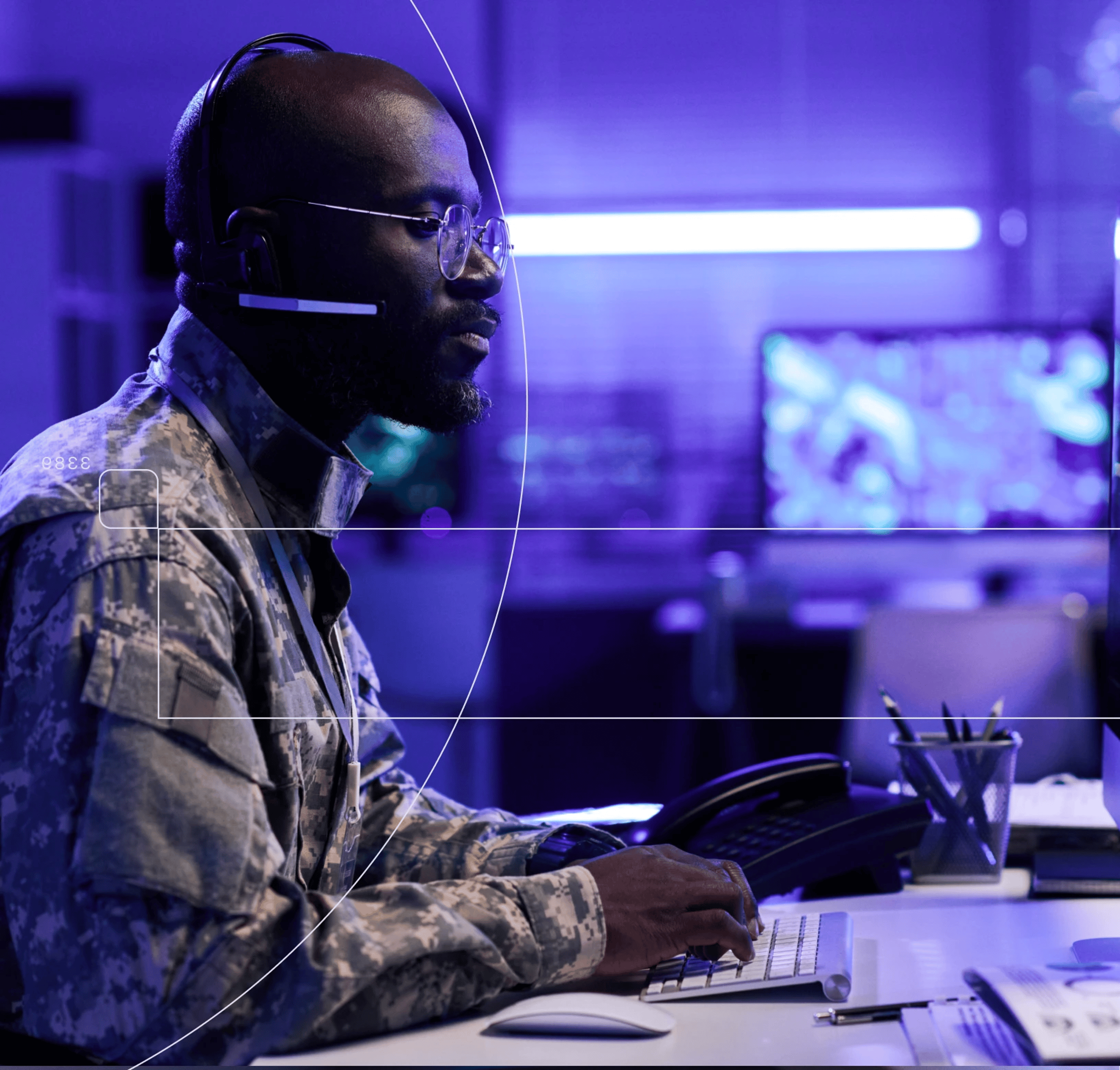 Man with headset at a desk using a keyboard, purple-blue dim lighting, with overlay lines/arcs suggesting monitoring