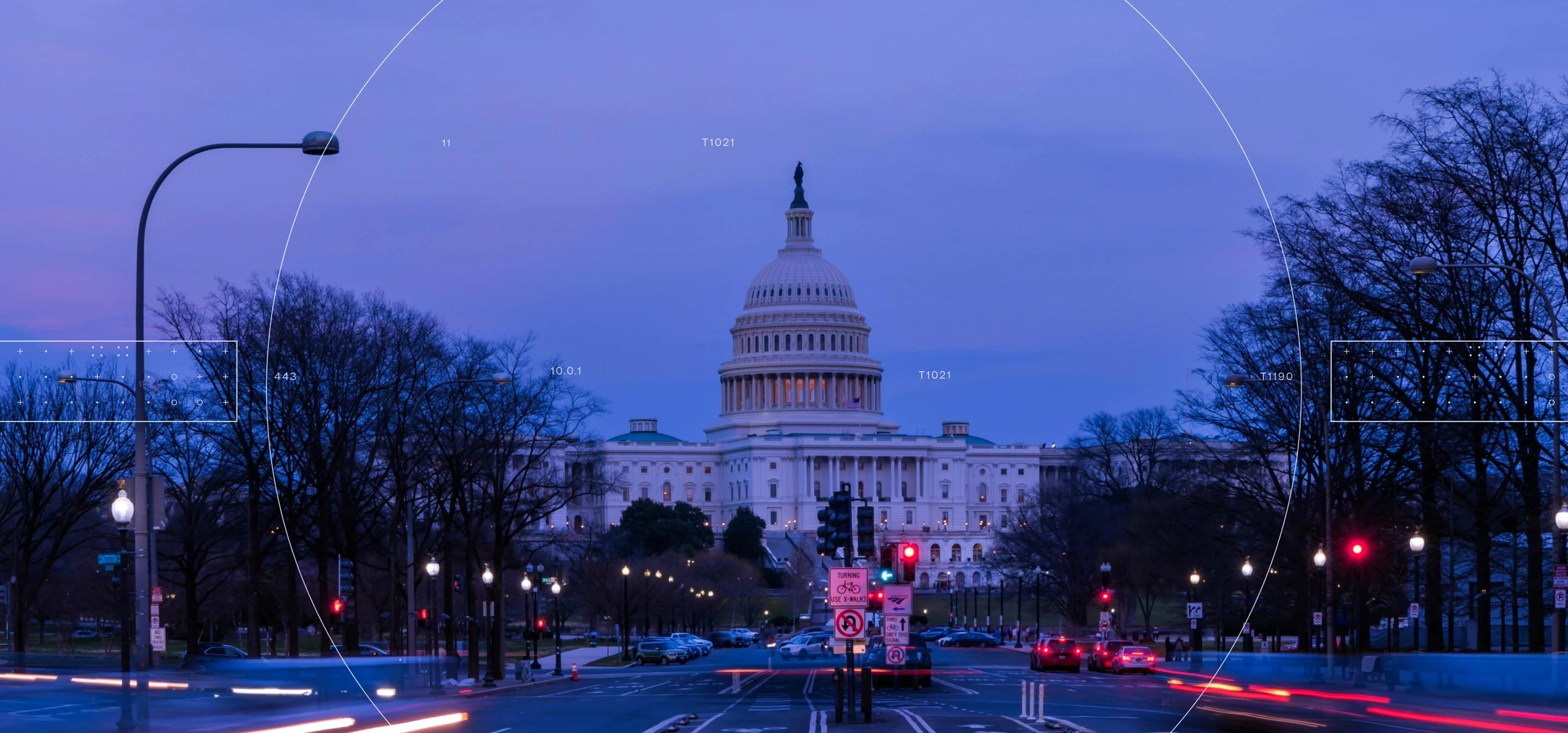 Dusk/night view of the U.S. Capitol with lit dome, bare trees, streetlights, traffic light signals, and vehicle light streaks plus faint camera overlay