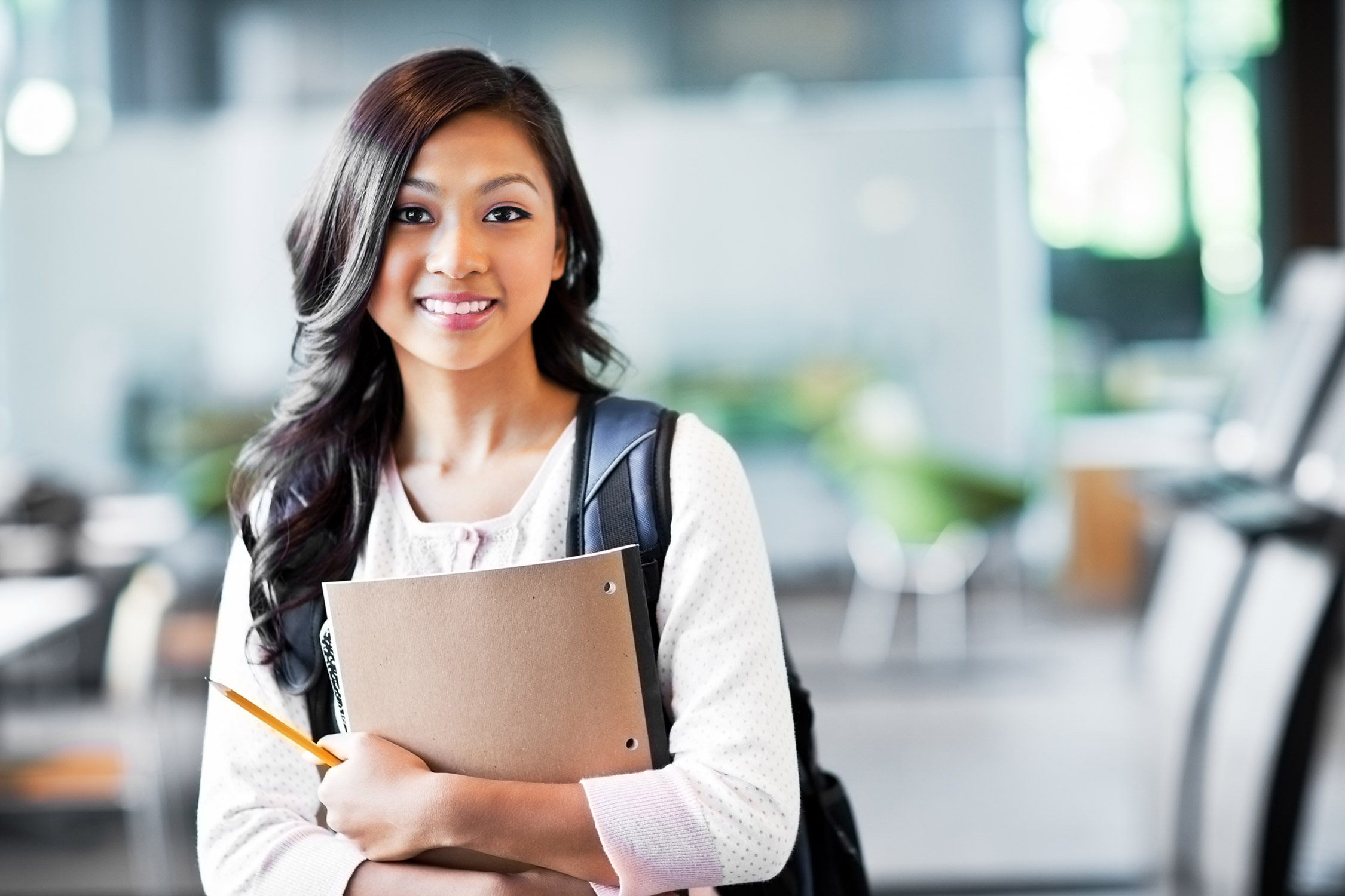 Girl holding notebook in school.