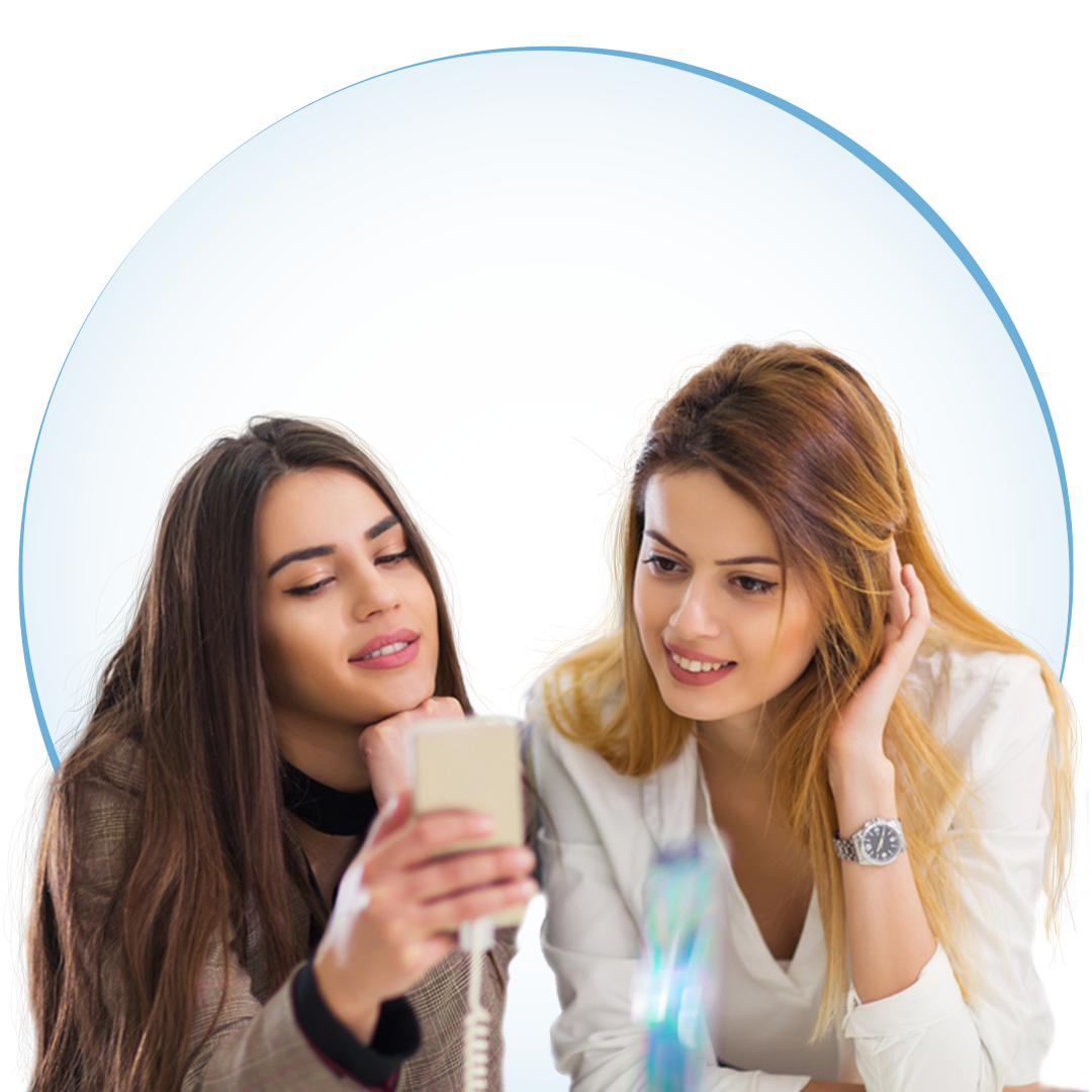 Two teen girls looking at a cell phone.