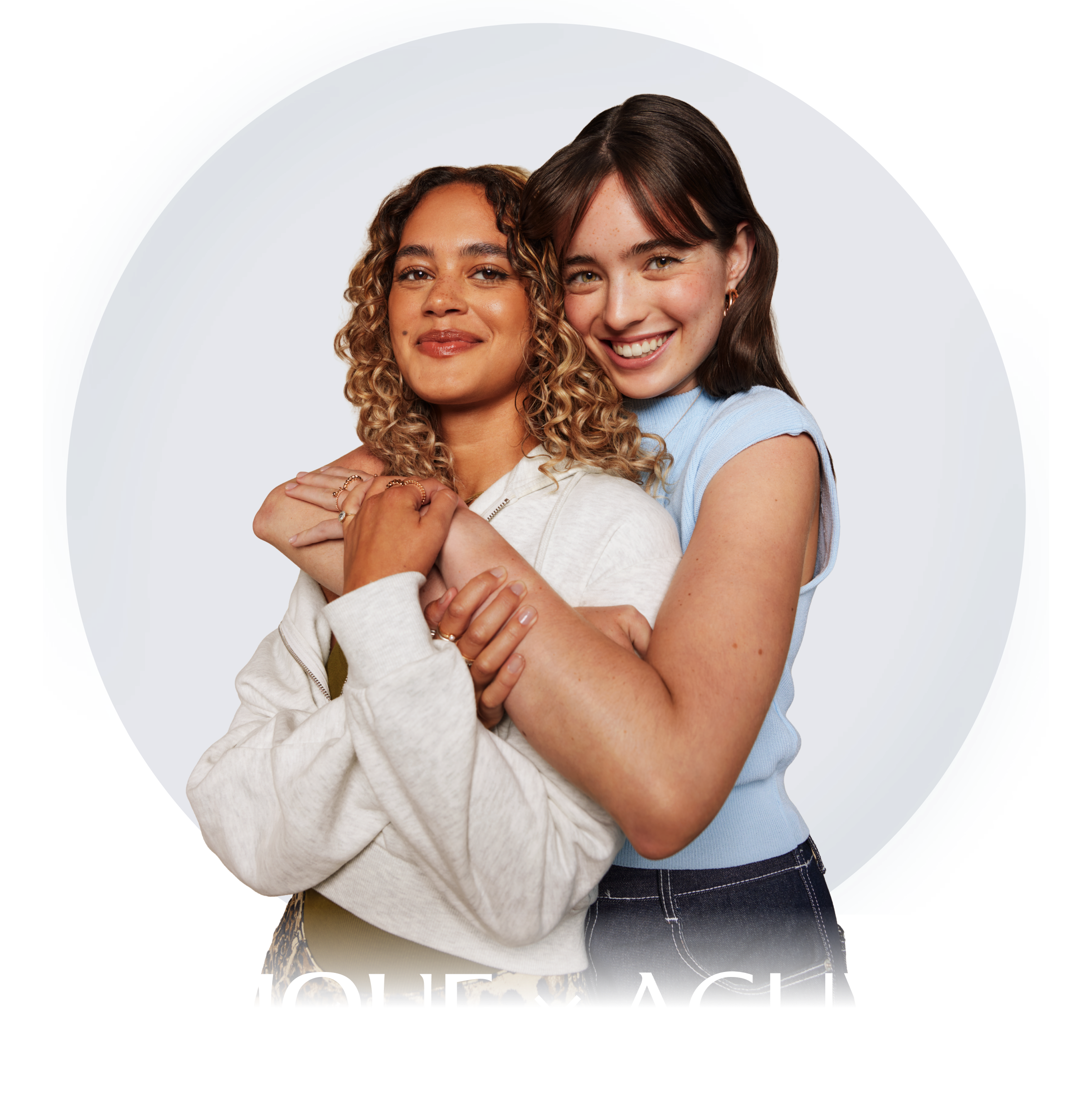 2 young, smiling diverse women looking directly at camera