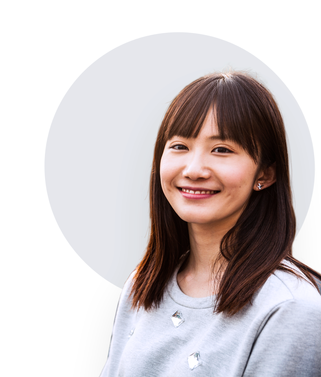 Young Asian woman with shoulder-length hair, and gray blouse.