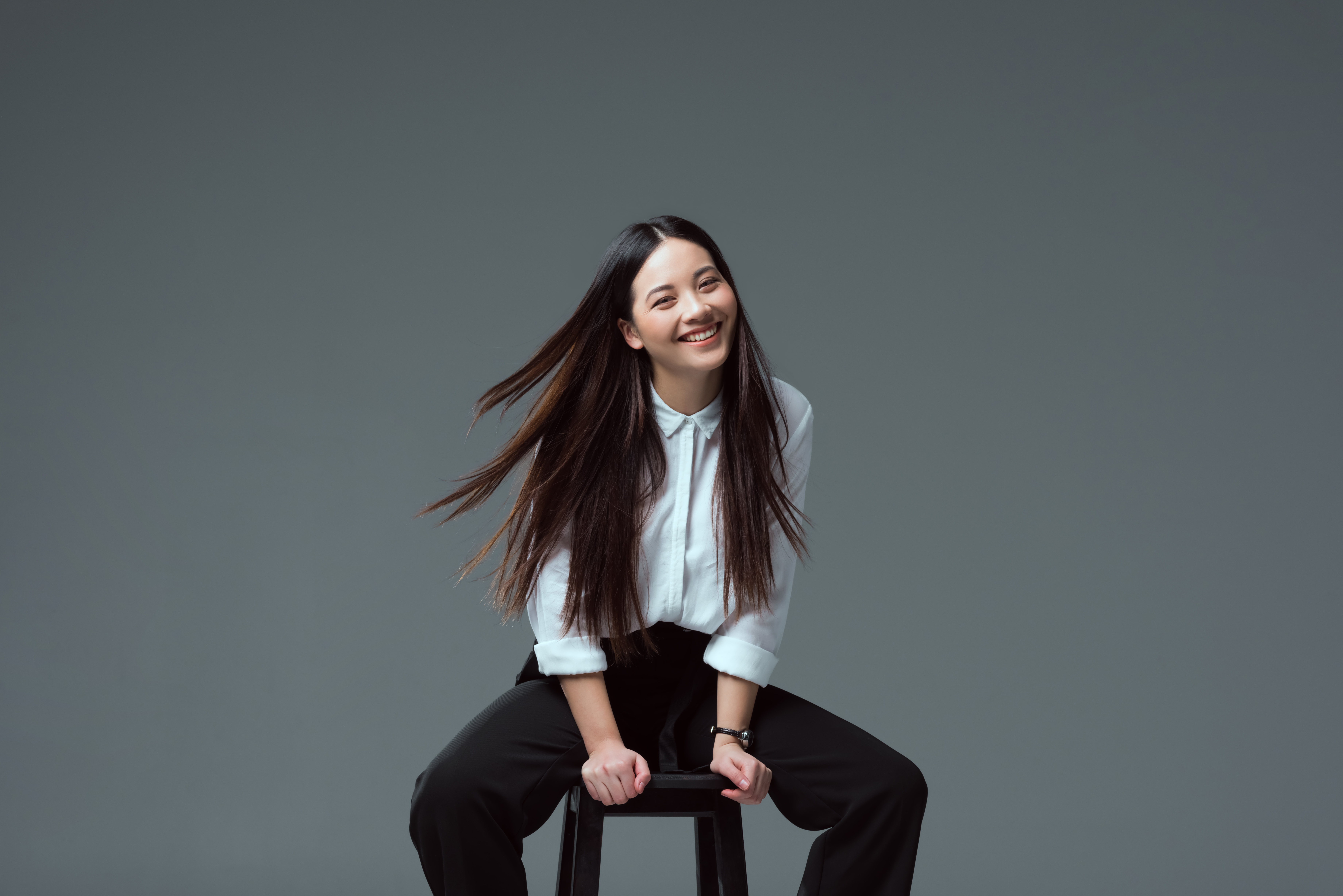 A young woman smiling directly into the direction of the camera