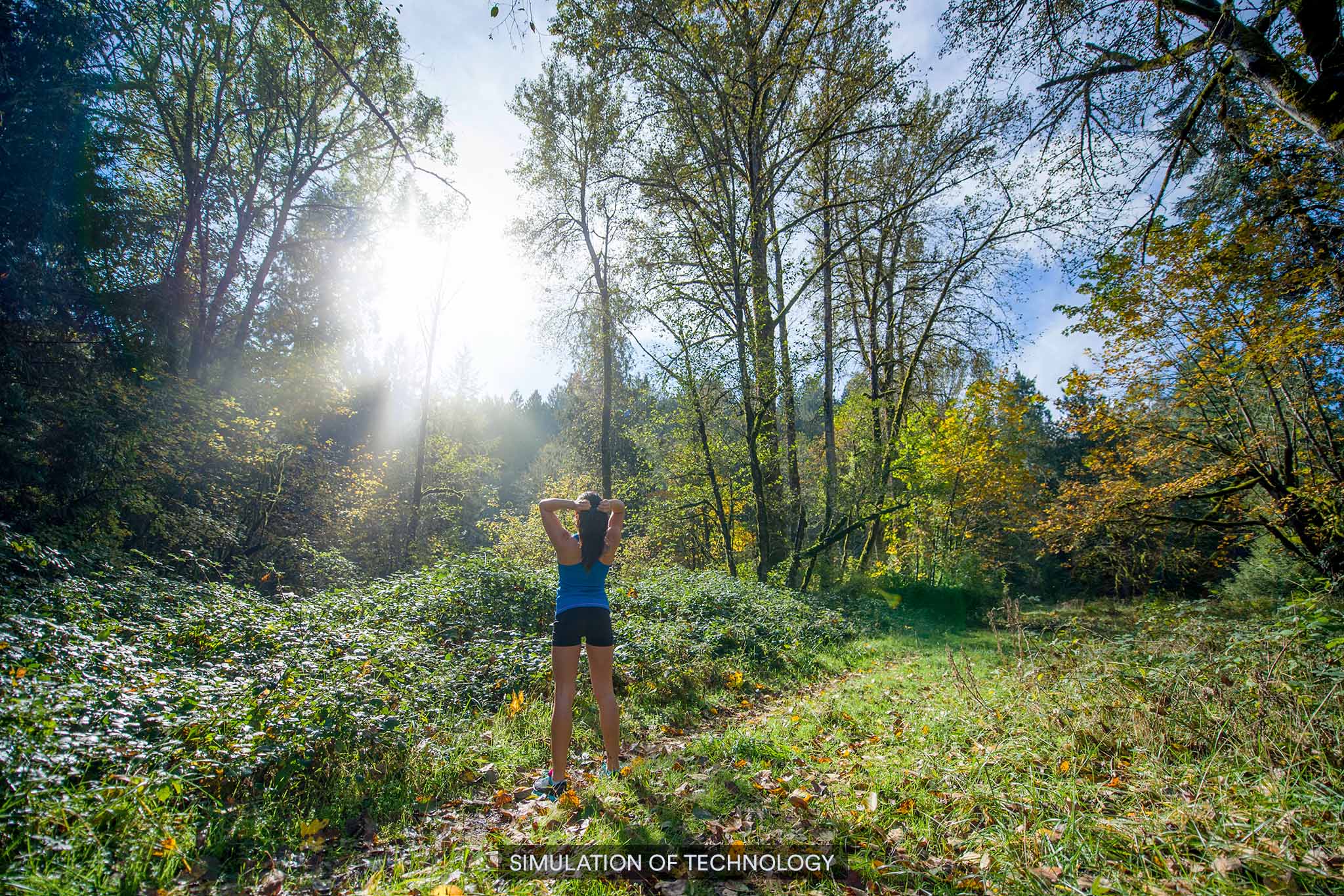 Eine Frau beim Wandern im Wald mit Sonnenlicht, das durch die Bäume scheint, ohne Kontaklinse