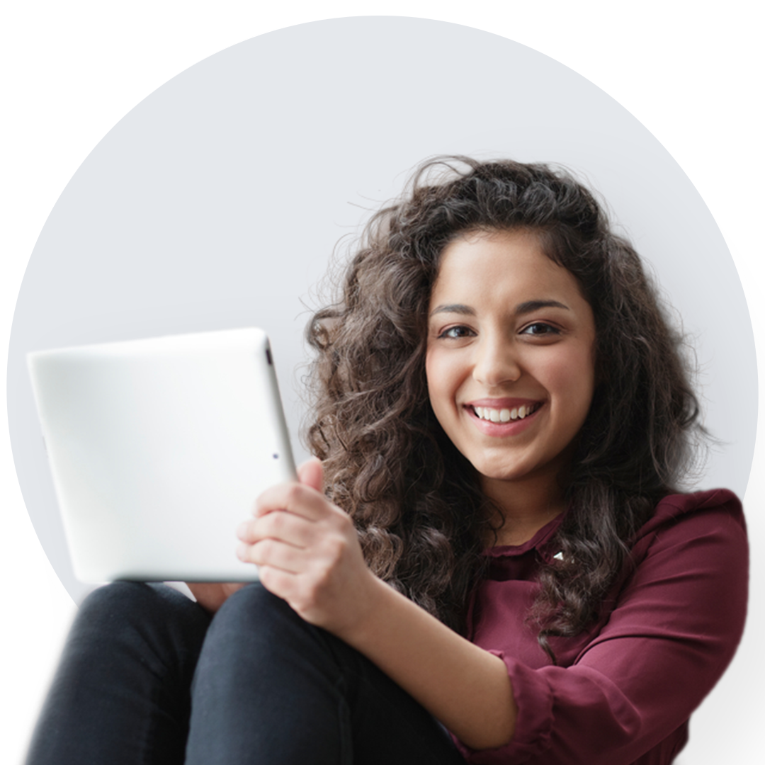 Joyful woman with wavy hair in maroon blouse, holding a tablet. Smiling woman with thick wavy hair, dressed in a maroon blouse, holding a tablet.