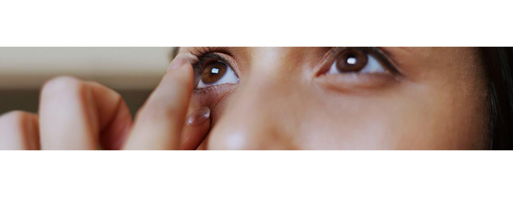   Extreme close up of model trying to put on contact lens