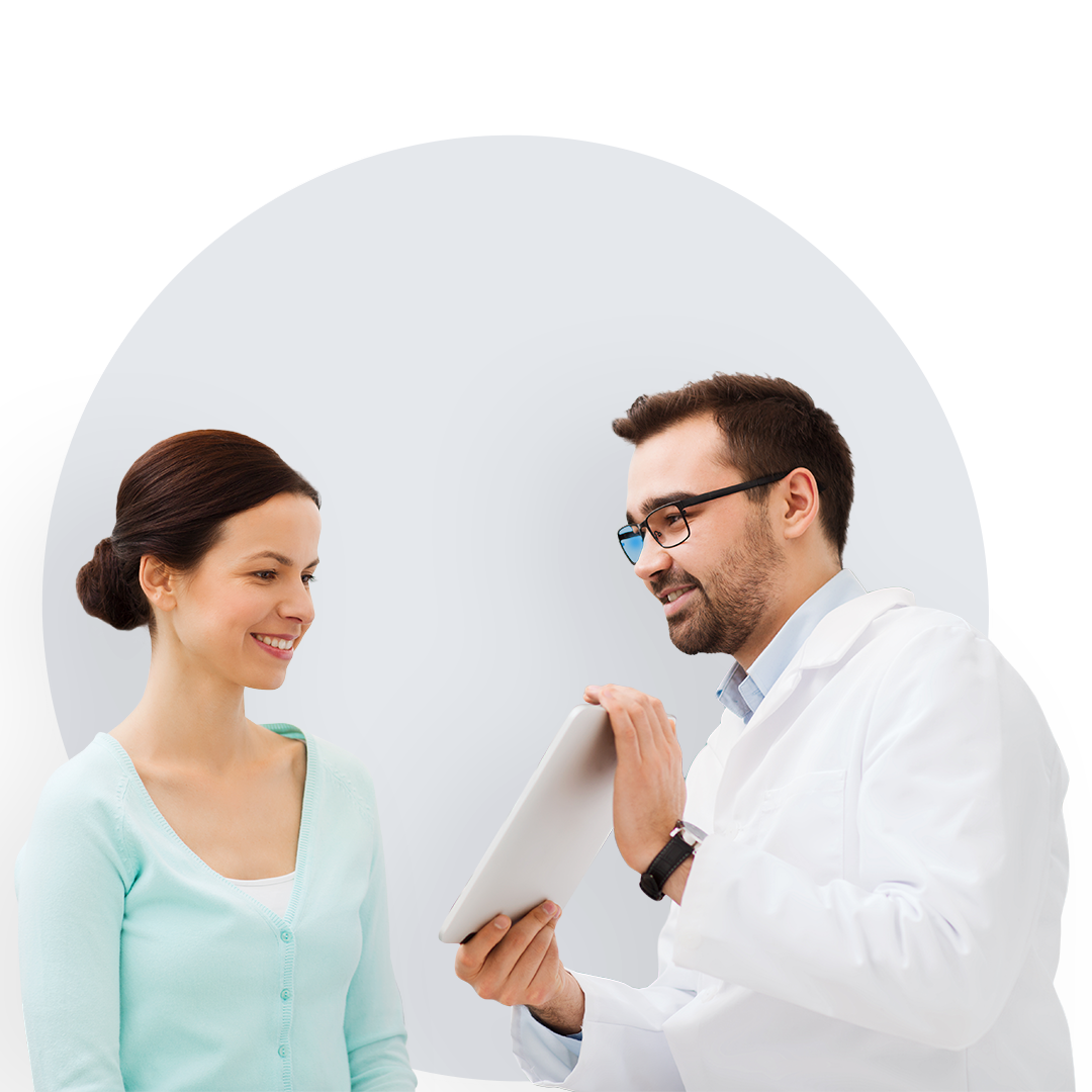 Smiling young woman being shown a tablet by a doctor.