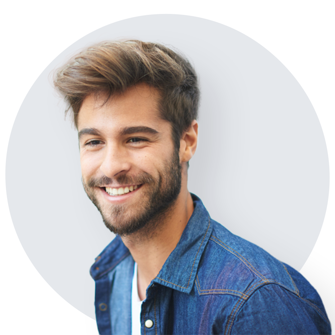 Smiling bearded young man in blue denim button down shirt.