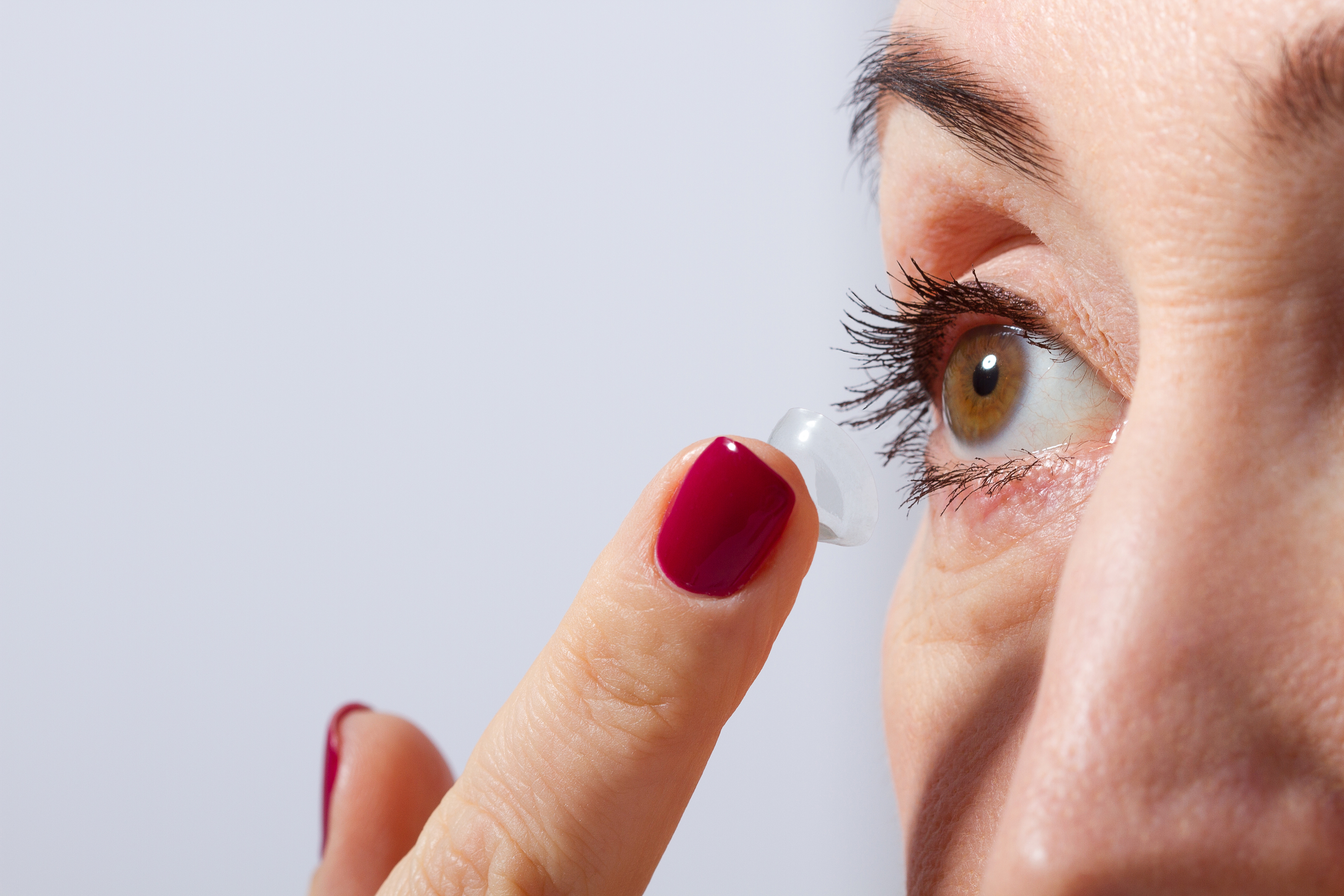 A woman inserting a contact lens.