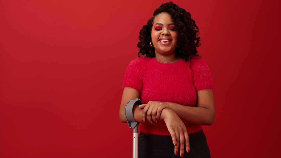 A black woman standing in front of a red background.