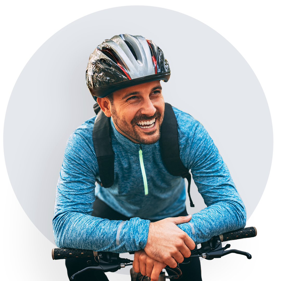 Man riding bicycle with helmet, wearing seafoam blue sweatshirt. Smiling man riding a bicycle with a black helmet, dressed in a comfortable seafoam blue sweatshirt.