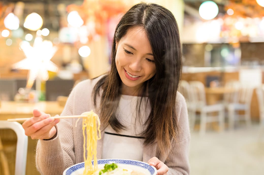  Lady enjoying her bowl of hot steaming ramen soup