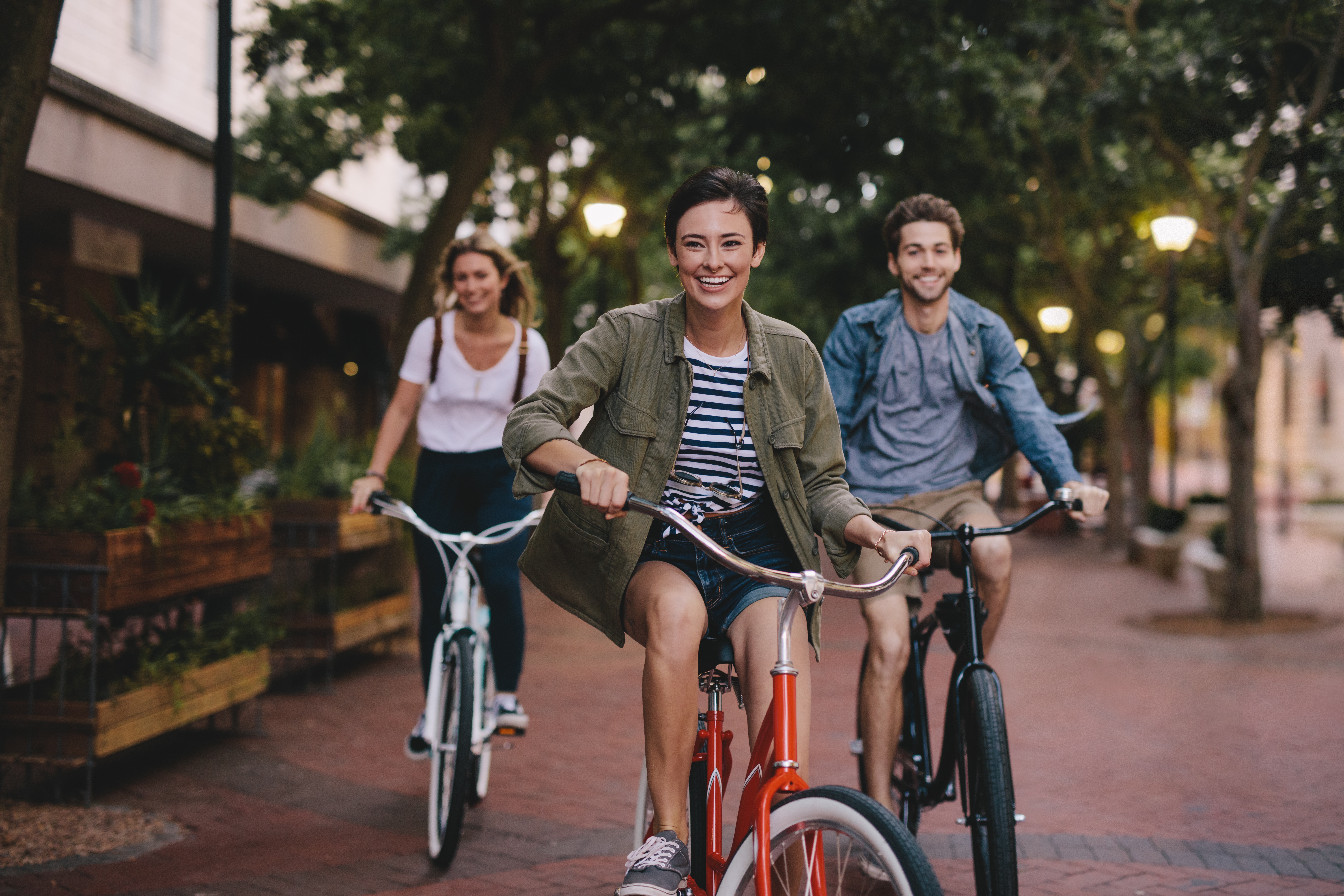 Uśmiechnięci młodzi ludzie jadący rowerami