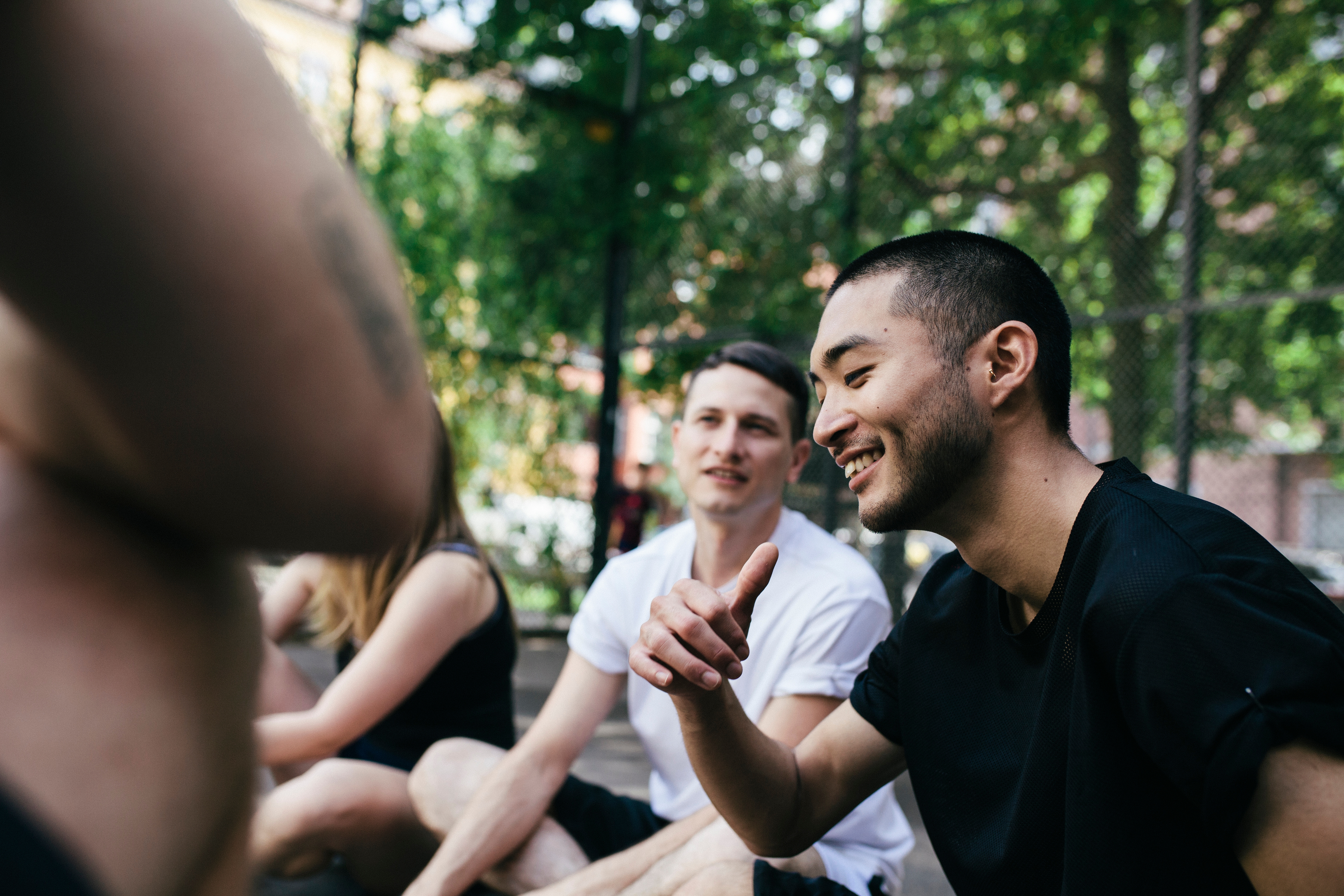 A group of young teens chatting sitting in circle at the park