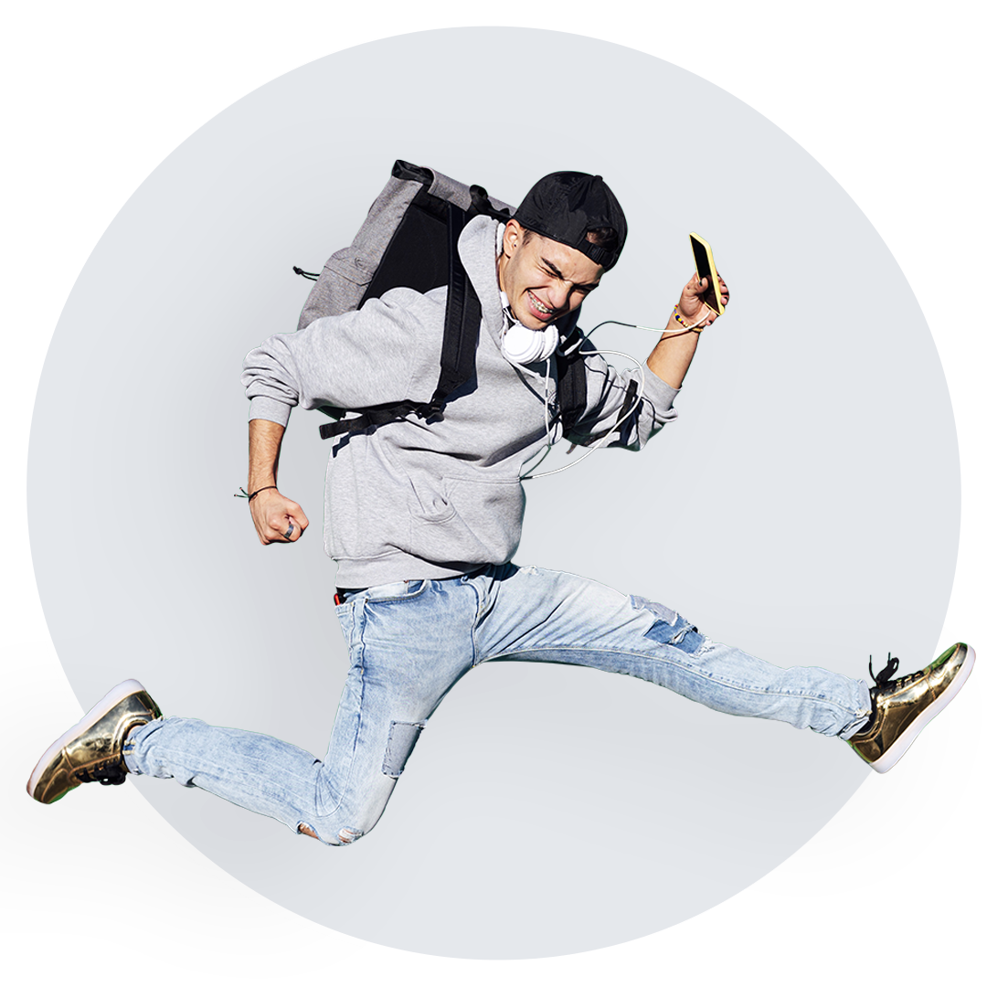 Teenage boy wearing backpack jumping.