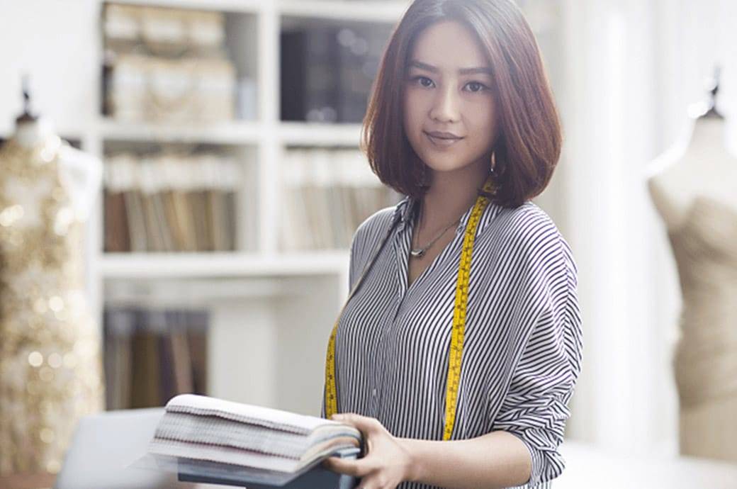  Fashion designer looking head on to the camera in work place