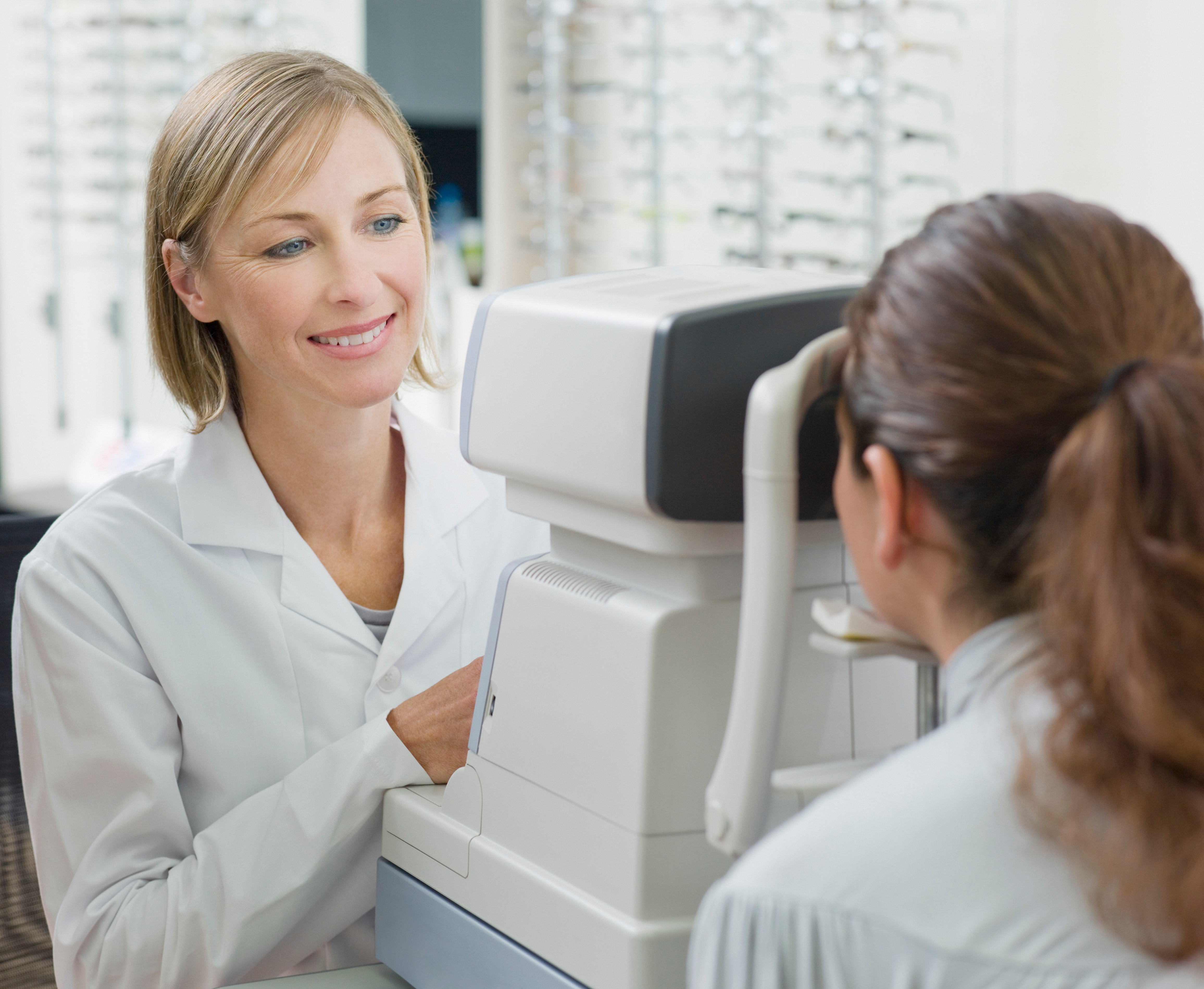 An eye doctor performing a vision test with a tonometer in her office.