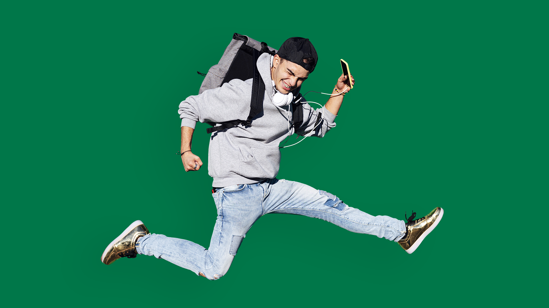 Teenage boy with backpack jumping.