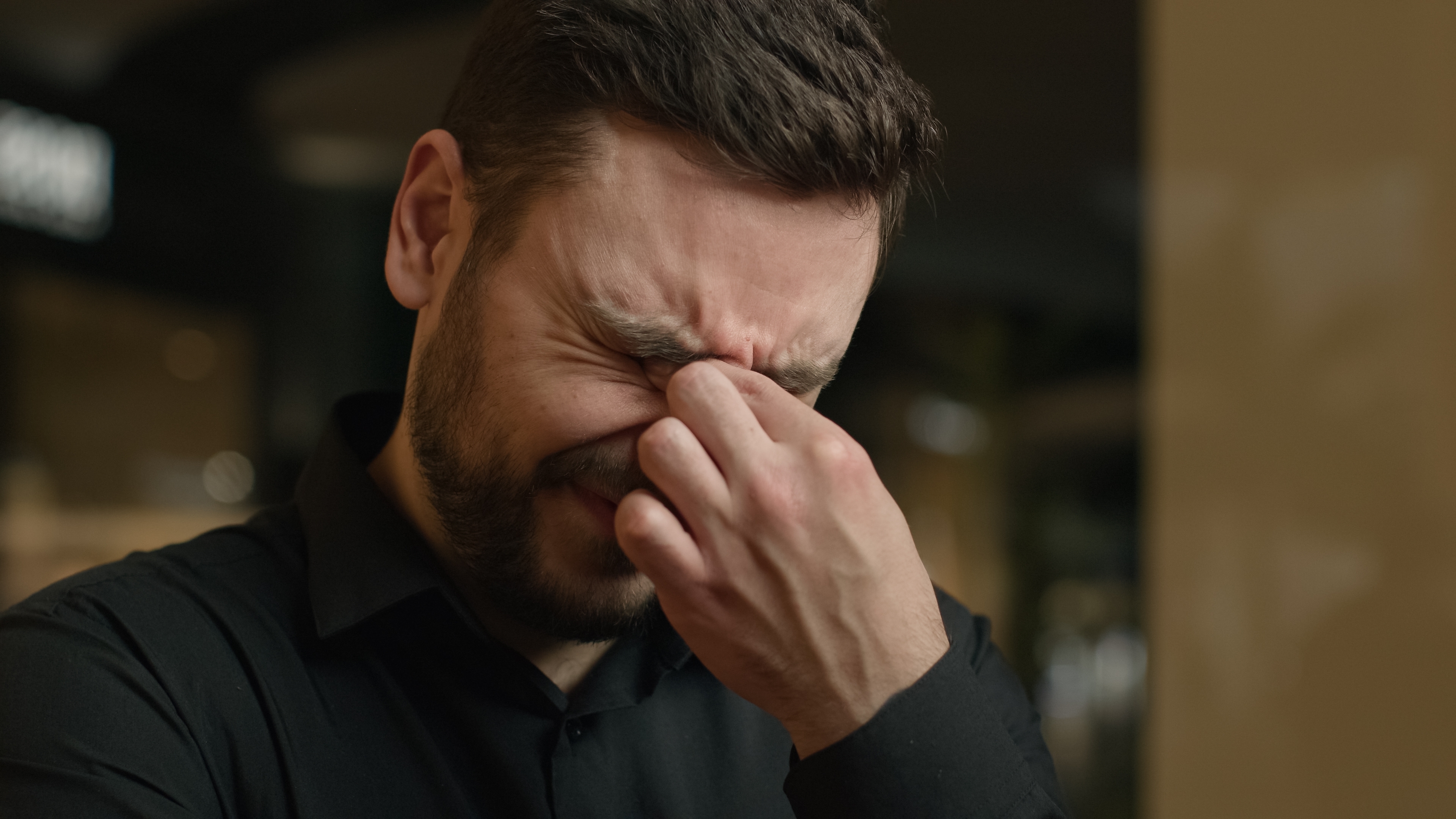 Mężczyzna pocierający oczy