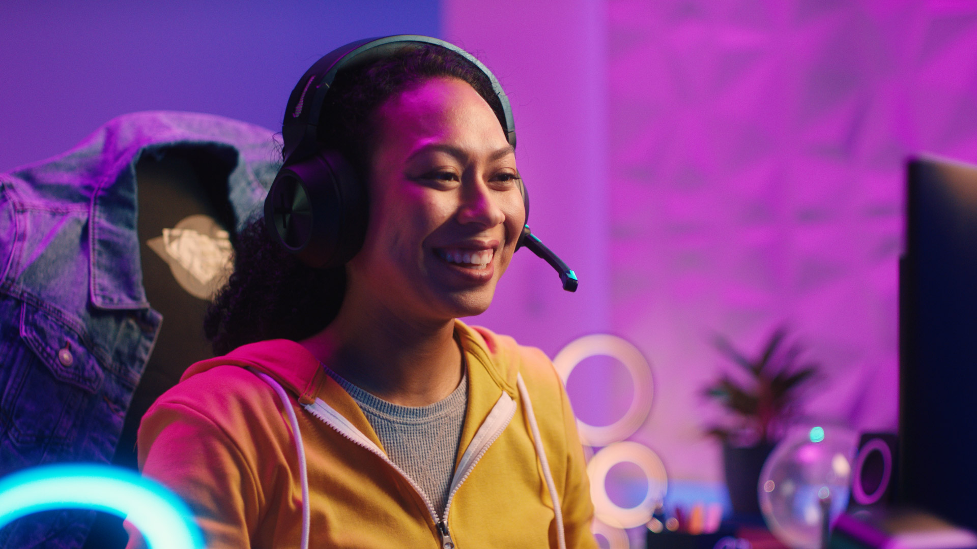A young woman wears a gaming headset to play video games.