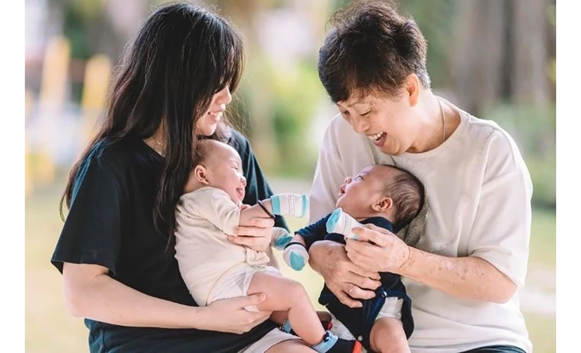 子どもを抱いている夫婦