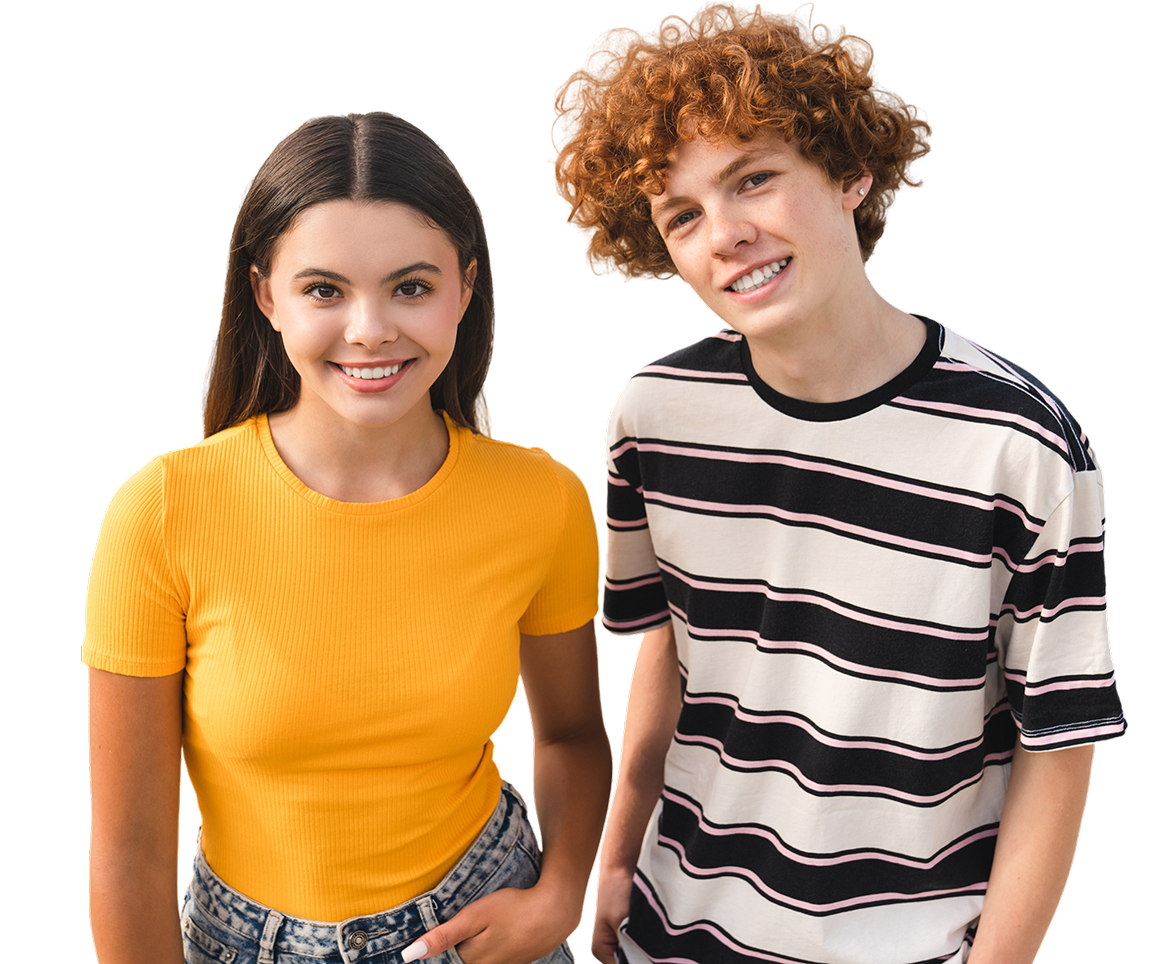 Два подростка, девочка и мальчик, улыбаются, глядя в камеру Девочка и мальчик смотрят в камеру и улыбаются