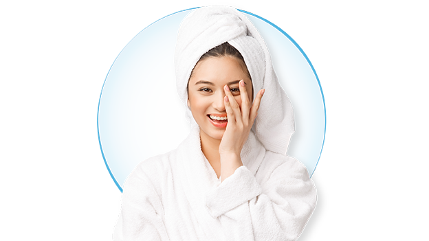 Woman in bathrobe getting ready to remove contact lens.