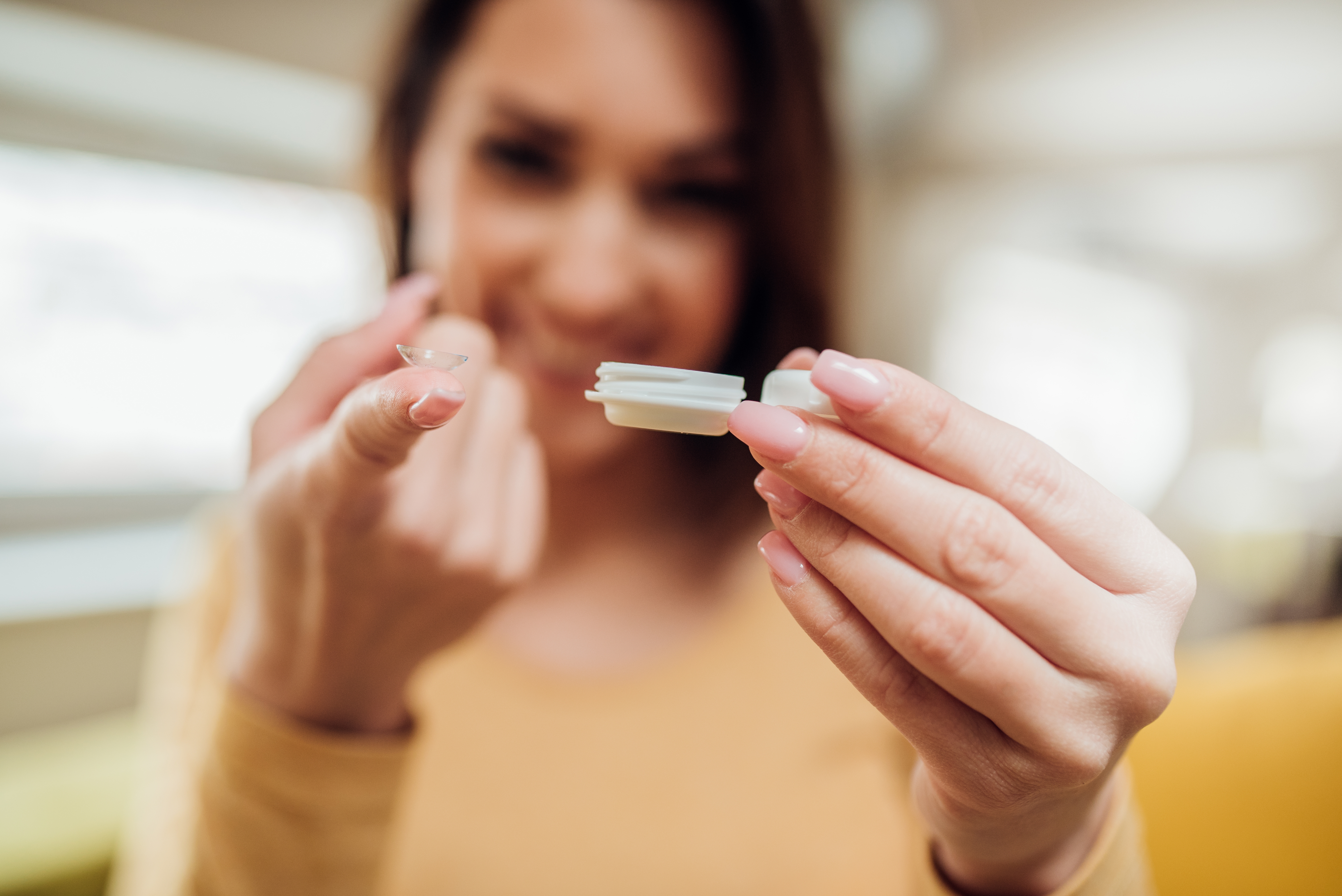 Blurry woman with lens on finger