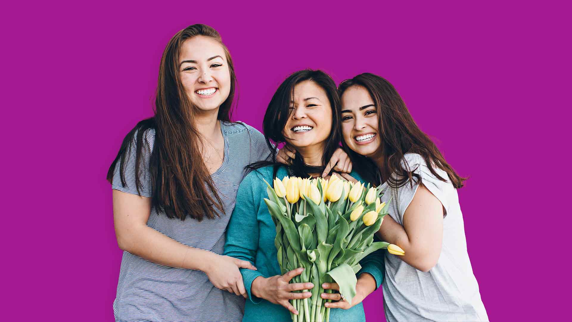 Une Maman tenant des tulipes jaunes avec ses deux filles la serrant dans leurs bras