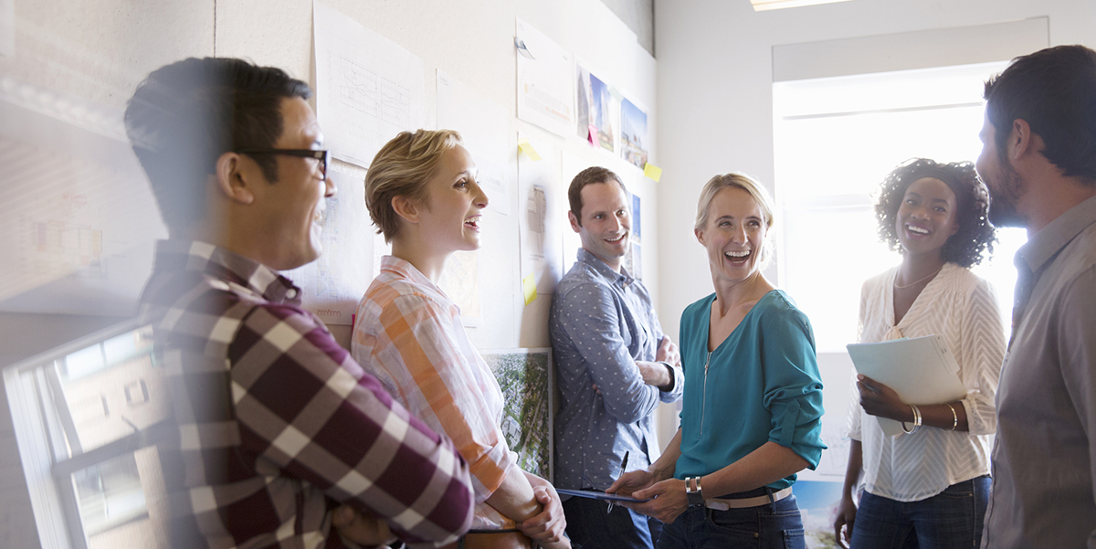 a diverse team of four salespeople working together with positivity as a result of enterprise sales training