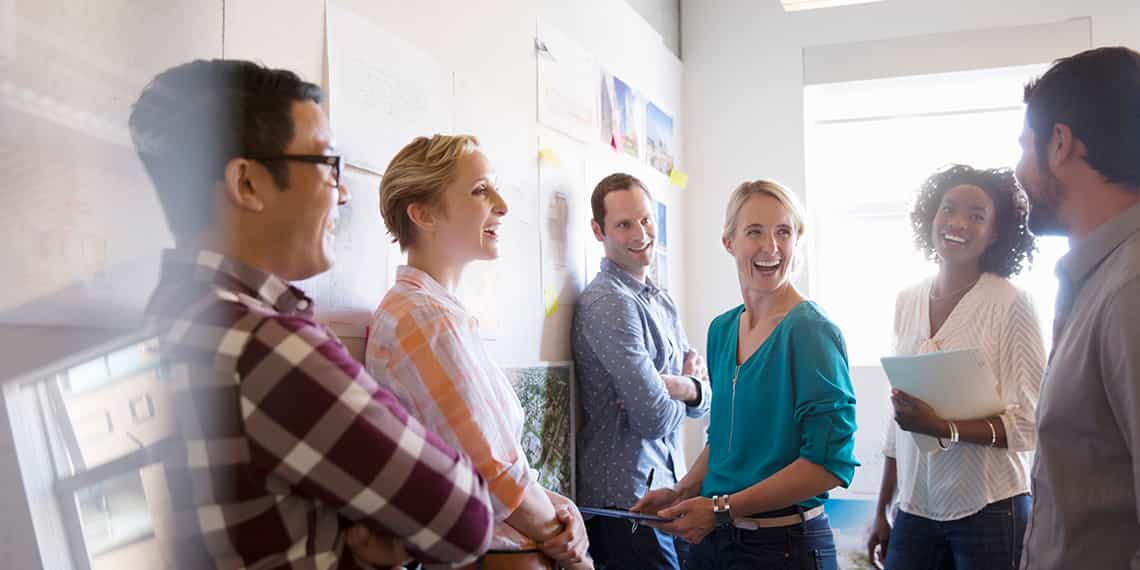 a diverse team of four salespeople working together with positivity as a result of enterprise sales training