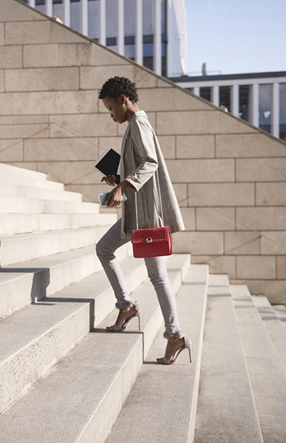 confident sales woman walking up the stairs on her way to a meeting with clients where she is going to use the Challenger approach to drive the deal forward