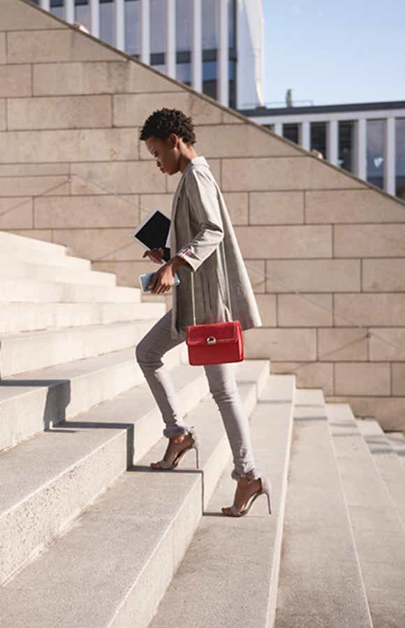 young sales woman walking confidently up the outdoor stairs of an office building ready to use her challenger selling skills to advance the sale