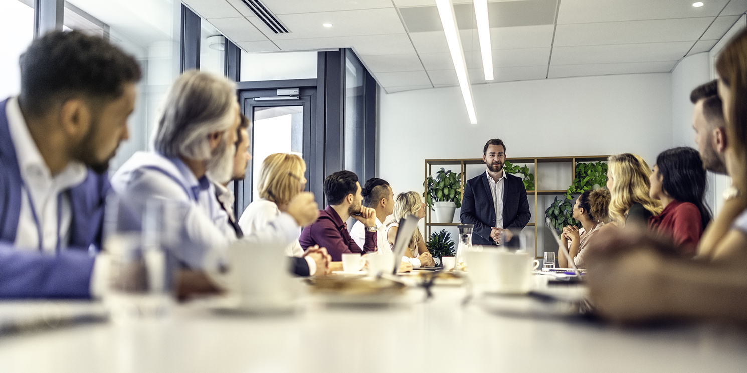 full sales team looking to their manager for answers in a modern conference room