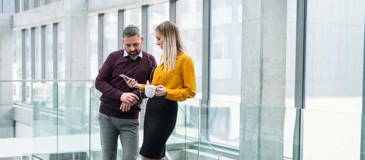 two sales professionals looking at a the status of an account on their phone, excited to see the progress they're making because of the skills they built in the prosperous account strategy training program