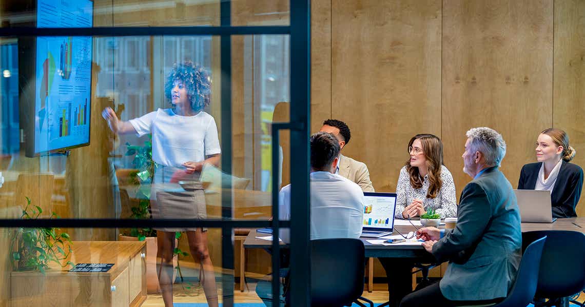 group of sales enablement and sales leaders in a warm office mapping out a sales onboarding program to improve time to productivity