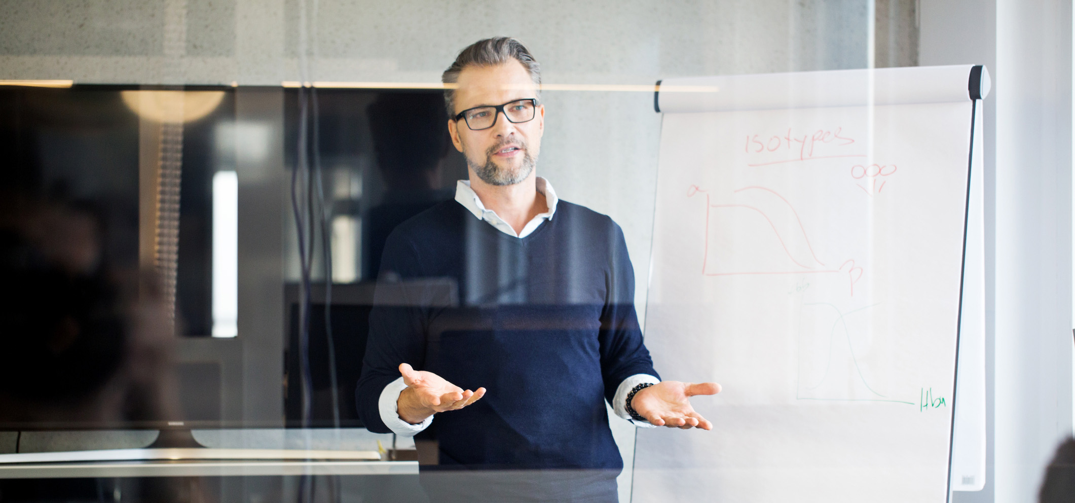 revenue operations leader hosting a team meeting in front of a white board, talking about organizing the revops team