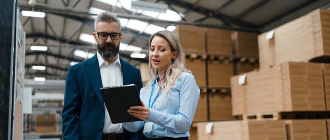 Sales manager and seller discussing a deal on a tablet.