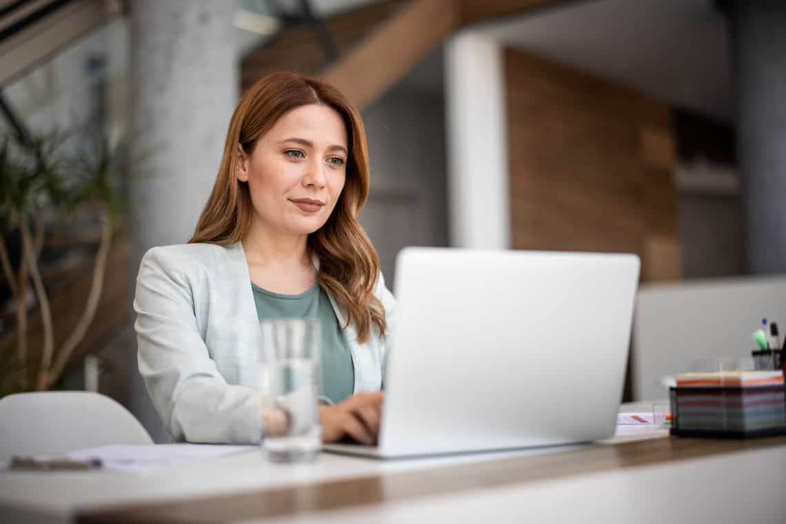 professional woman sitting a computer doing research into sales training