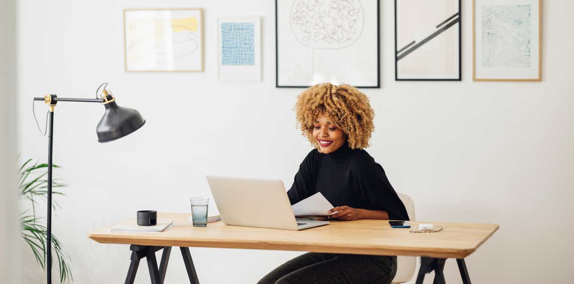 picture of a sales woman sitting at a modern desk entering data into the company's CRM