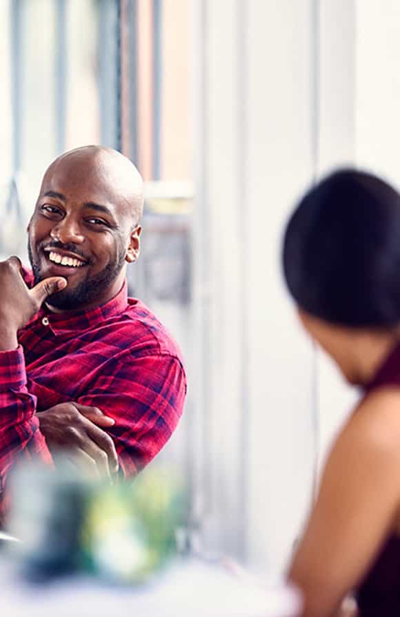 two sales professionals sitting at a desk looking happy because they have the soft selling skills they need to succeed thanks to richardson's six critical skills training program